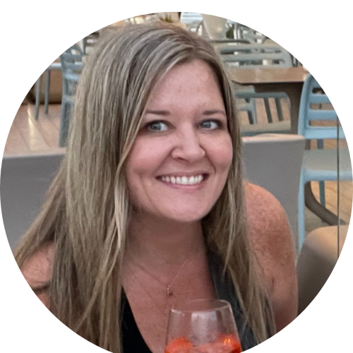 Smiling traveler enjoying a drink, seated at a cozy outdoor setting, with a relaxed and happy expression.